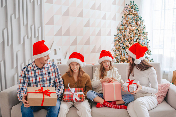 Ευτυχισμένη οικογένεια με παιδιά να κρατάνε χριστουγεννιάτικα δώρα. - Φωτογραφία, εικόνα