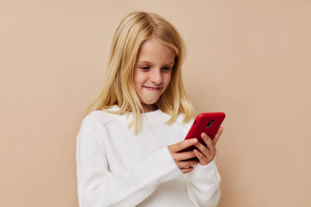 Little cute girl communication smartphone entertainment on a beige background - Photo, image
