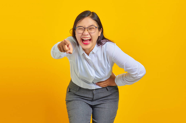 Portret van jonge zakenvrouw lachend van harte om grappige gekke grap met handen op het lichaam - Foto, afbeelding