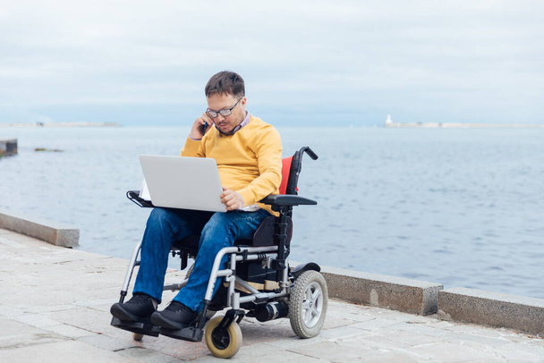 a man with a disability in a disabled working business remotely - Photo, Image