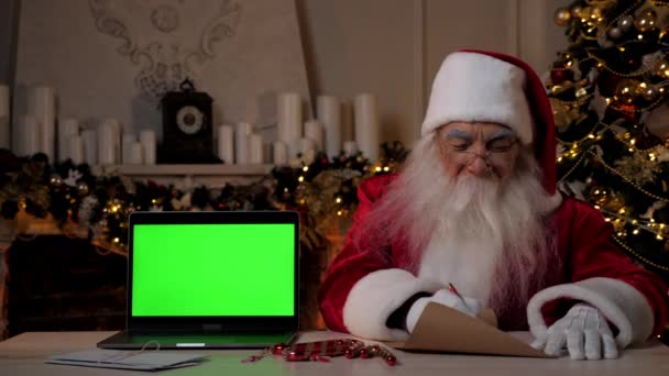 Kerstman schrijft felicitaties kinderen met Nieuwjaar, laptop groen scherm - Video