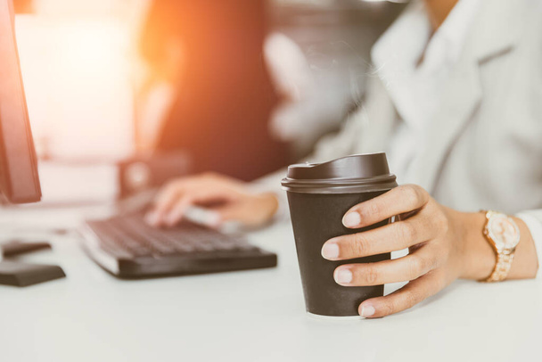 Hand an Kaffeetasse im Büro. Geschäftsleute trinken Kaffee aus Pappbecher für gutes Arbeitskonzept - Foto, Bild