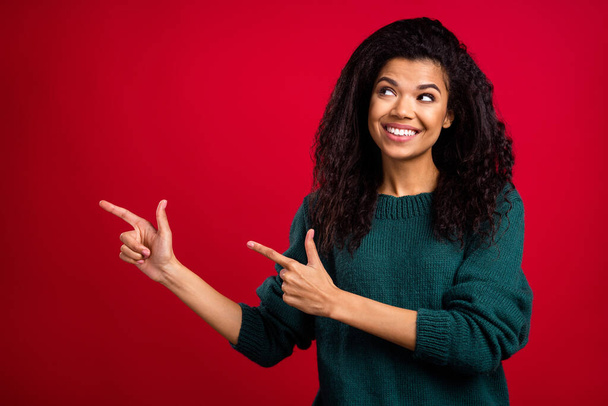 Photo of pretty nice afro american young woman look point finger empty space isolated on red color background - Fotoğraf, Görsel