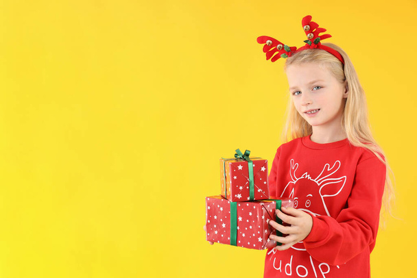 Pieni tyttö joulun laatikot keltaisella taustalla - Valokuva, kuva