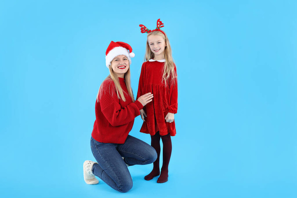 Mom and daughter on blue background, Christmas concept - Photo, Image