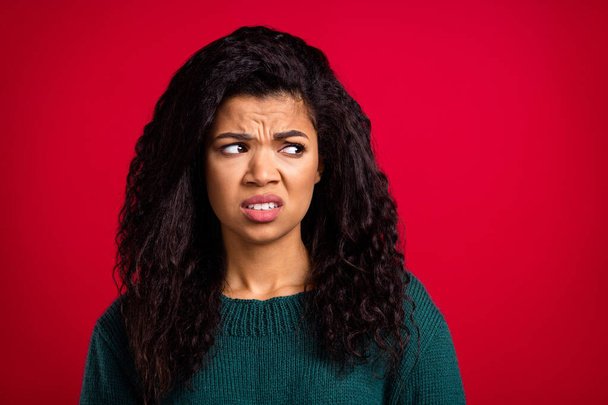 Photo of disgusted unhappy dark skin young woman look empty space dislike face isolated on red color background - Zdjęcie, obraz