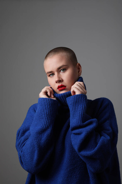 Vertical portrait of beautiful bald young woman, wearing blue sweater. Isolated. - Fotó, kép