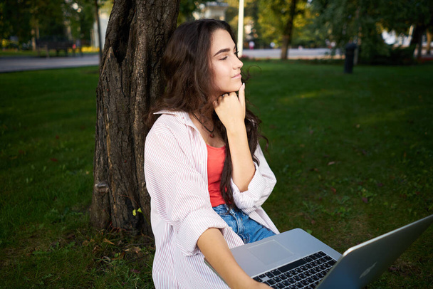 γυναίκα με φορητό υπολογιστή κάθεται στο γρασίδι Lifestyle Καθαρός αέρας - Φωτογραφία, εικόνα