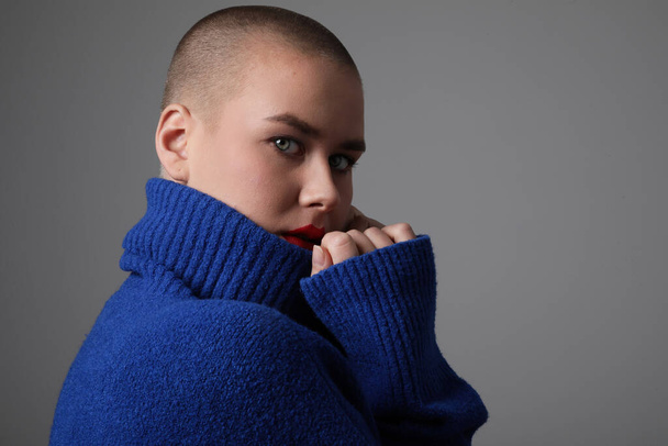 Portrait of beautiful bald young woman, wearing blue sweater. Isolated. - Fotoğraf, Görsel