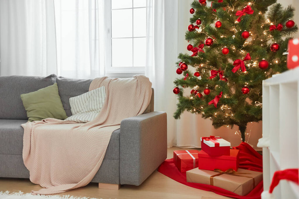 Christmas Home Interior. Stylish Living Room With Christmas Tree, Sofa and Gift Boxes With Presents - Фото, зображення