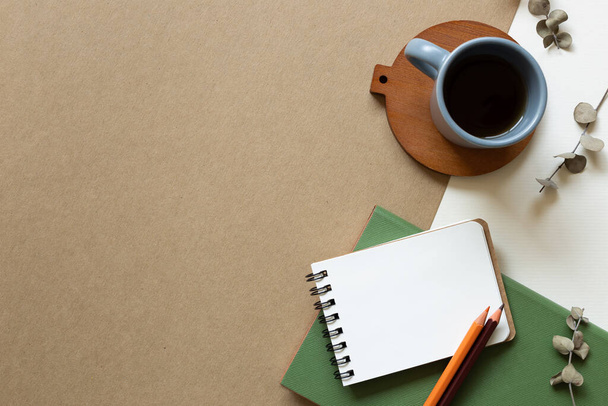 Tagebuchnotiz und Tasse Kaffee auf braunem und weißem Hintergrund. flache Lage, Draufsicht, Kopierraum - Foto, Bild