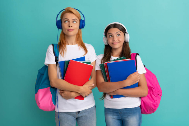 nachdenkliche Privatlehrerin und Kind in Kopfhörern mit Schulbuch und Schultasche, - Foto, Bild