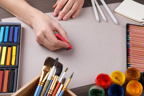 Artist drawing with chalk pastel at wooden table, closeup - Foto, Imagen