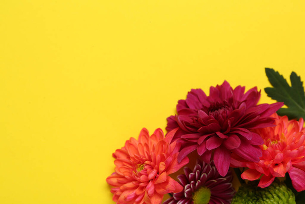 Beautiful chrysanthemum bouquet on yellow background, top view. Space for text - Fotó, kép