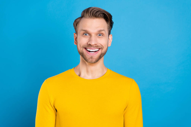 Photo of young excited man happy positive smile amazed surprised news sale isolated over blue color background - Foto, Imagen