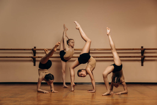 Skupina roztomilých moderních baletek pózujících během choreografického tance. Kvalitní fotografie - Fotografie, Obrázek