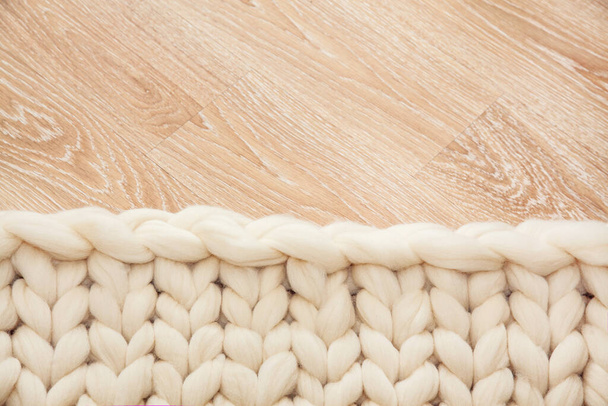 Plaid tricoté de gros tricot en laine mérinos sur sol en bois. - Photo, image