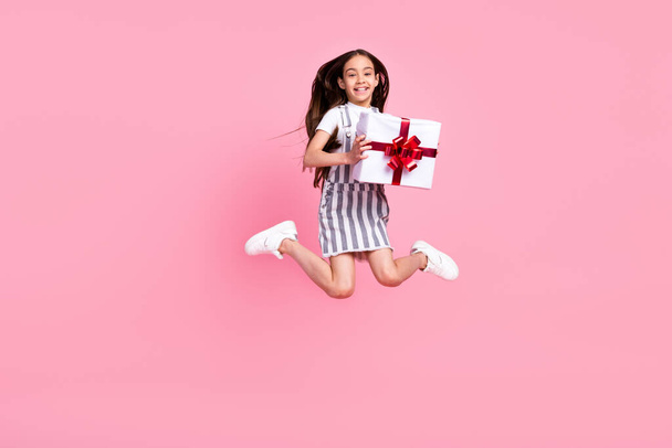 Full length photo charming happy attractive girl jump hold hands present isolated on pink color background - Foto, imagen