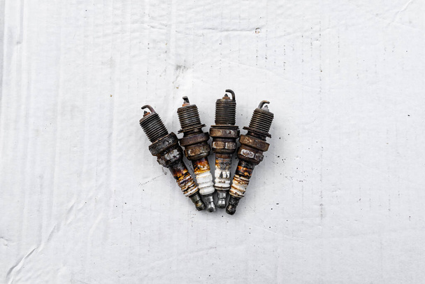old used car spark plugs in rust on a white background. - Photo, image