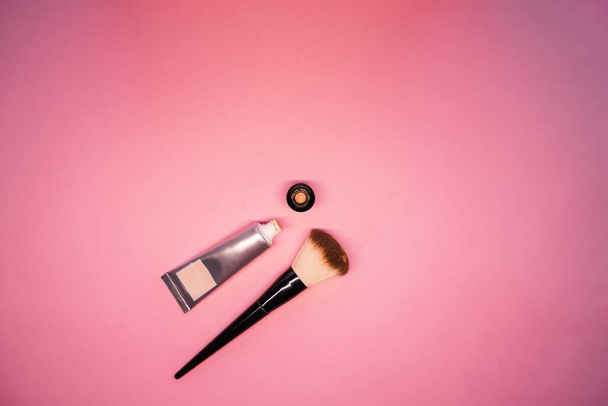 foundation for the face with a brush on a pink background top view. makeup accessories. decorative cometic for the face. facial skin care product - Photo, Image