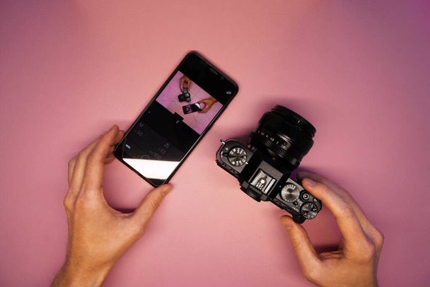 Ένας άντρας συνδέει την κάμερα με ένα smartphone. τηλέφωνο ελέγχου κάμερα πάνω όψη. σύγχρονες τεχνολογίες στον κόσμο της τεχνολογίας φωτογραφιών και βίντεο - Φωτογραφία, εικόνα