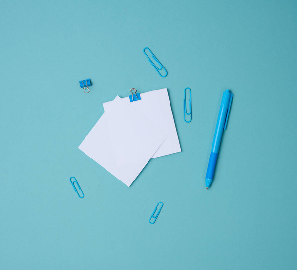 Notlar için beyaz kare kağıt yığını, mavi arkaplan üzerinde kırtasiye, üst görünüm - Fotoğraf, Görsel