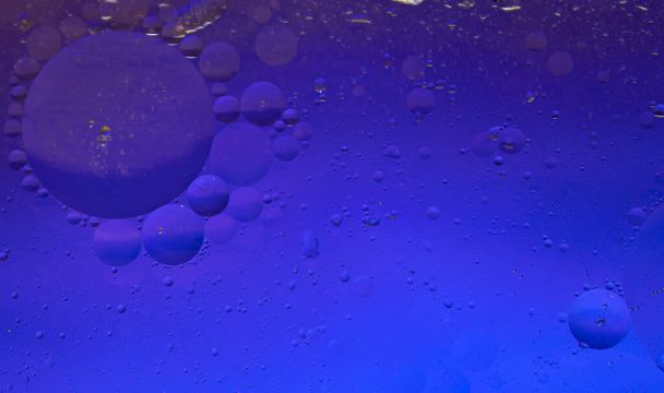 Abstraktio kosmoksen. Vesi putoaa värillinen rakenne taustalla.Vesi öljyllä lasilla, yli värillinen tausta, kuplia vedessä. Solut, vesipisarat lasilla, lähikuva makro näkymä, vesi on elämä, valikoiva keskittyminen. - Valokuva, kuva