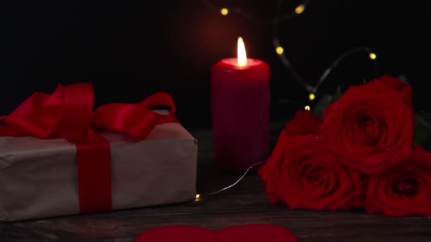 piros gyertya kézműves papír ajándék doboz rózsák a sötétben: romantikus szerelem társkereső háttér  - Felvétel, videó