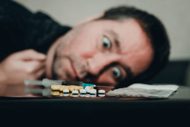 Addict, breaking, pain,depression,illness. Drug addict with crazy eyes.drug user looking dependent from different types of drugs. Drugs concept.Toned selective focus. - Photo, Image