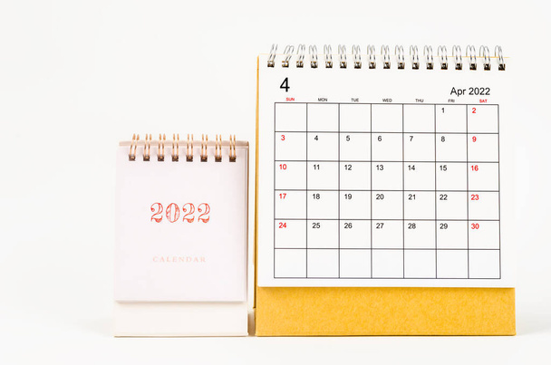 The April 2022 desk calendar on wooden table. - Фото, изображение