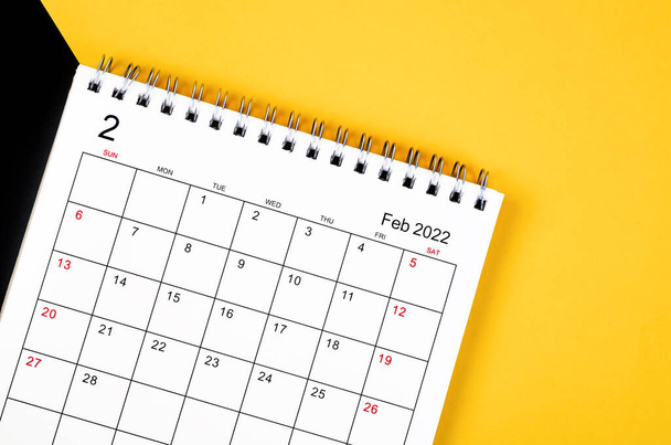 The February 2022 desk calendar on yellow and black background. - Photo, image