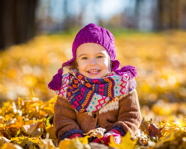 Happy little girl playing in the autumn park - Фото, зображення