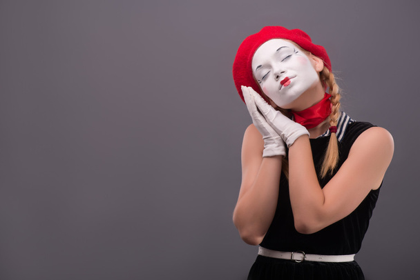 Waist-up portrait of young mime girl showing something - Foto, imagen