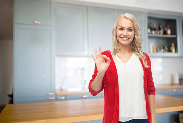 happy young woman showing ok hand sign on kitchen - Foto, afbeelding