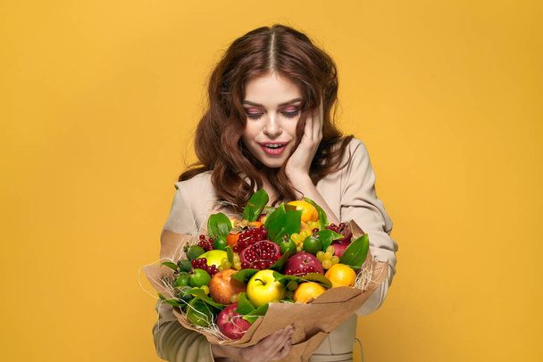 portrait of a woman fun posing fruit bouquet vitamins colorful background - Foto, Imagen