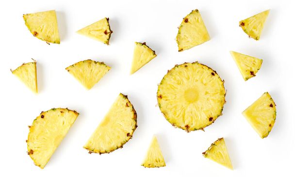Composition of pineapple pieces and slices isolated on white background, top view - Foto, immagini