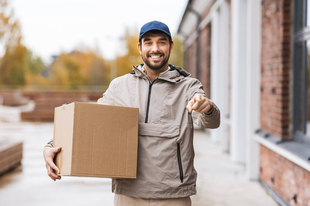 delivery man with parcel box pointing to camera - Zdjęcie, obraz