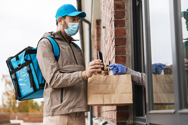 food delivery man in mask giving order to customer - Φωτογραφία, εικόνα