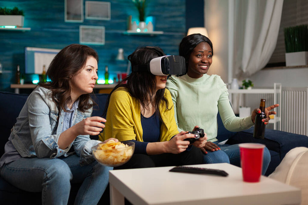 ゲームをプレイするコントローラを保持する仮想現実ヘッドセットを持つ集中女性 - 写真・画像