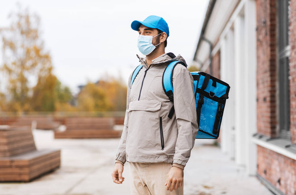 futár maszkban termál táskával a városban - Fotó, kép