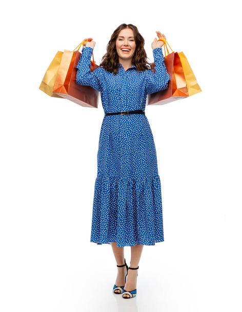 glückliche junge Frau im blauen Kleid mit Einkaufstaschen - Foto, Bild