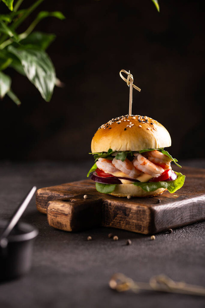 Delisious burger with shrimps on a wooden board - Фото, зображення