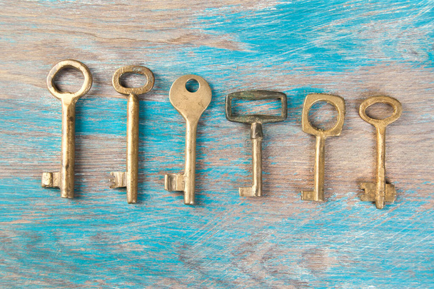 Staré mosazné klíče, detail klasických kovových klíčů na dřevěném pozadí. Kopírovat prostor pro text - Fotografie, Obrázek