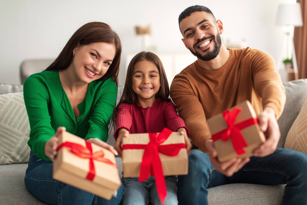 Portrait of happy Arab family celebrating holiday giving gift boxes - Photo, Image