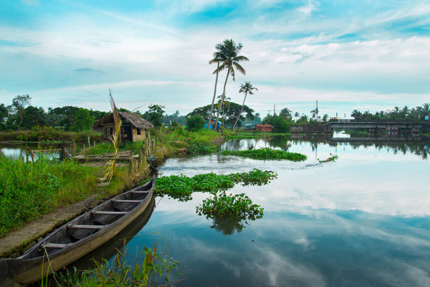 Wooden Boat In Backwater, typical landscape with palm trees and old hut, Kerala Backwaters, Kerala backwaters photography during day time Kadamakkudy Kerala, Stripe of coconut trees between a cloudy sky and river. - Foto, Imagem