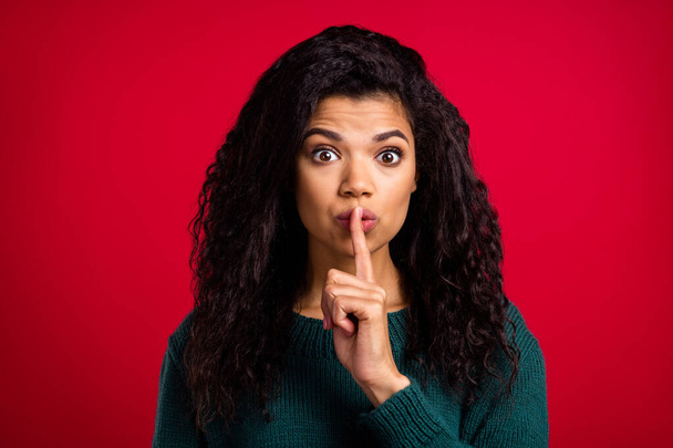 Photo of charming confident dark skin woman dressed green pullover finger lips ask not tell secrets isolated red color background - Valokuva, kuva