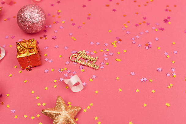 Golden christmas decorations on trendy pink background. Christmas New year or party banner. Copy space - Foto, imagen