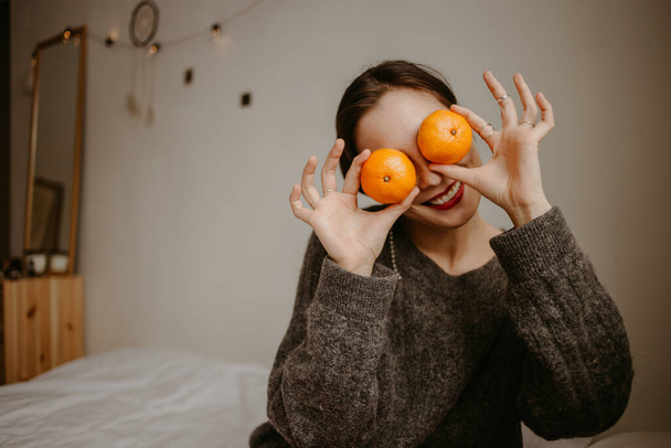 femme avec des mandarines à la maison - Photo, image