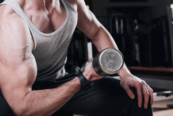  Izmos férfi edz a tornateremben gyakorolja súlyzók bicepsz Közelkép - Fotó, kép