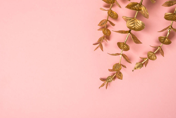 Golden palm leaves at pink background flat lay. - Φωτογραφία, εικόνα
